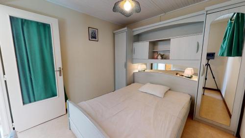 a small bedroom with a bed and a mirror at Maison de vacances proche du Port in Saint-Gilles-Croix-de-Vie