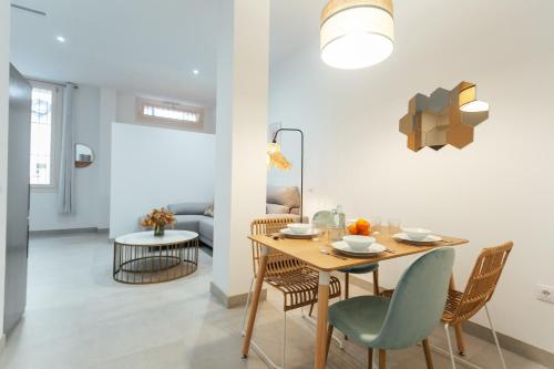 uma sala de jantar e sala de estar com mesa e cadeiras em Tu casa en un rinconcito del centro em Sevilha