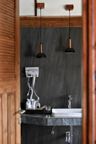 a bathroom with a sink and three lights at Pan's farm แบ่งปันฟาร์ม in Ban San Phaya Loei Luang