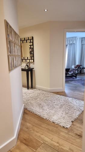 uma sala de estar com um tapete branco e uma mesa em Beautiful and modern Apartment in North London em Hendon