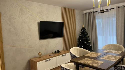 a dining room with a table and a christmas tree at Apartament Złoty 4 in Zblewo