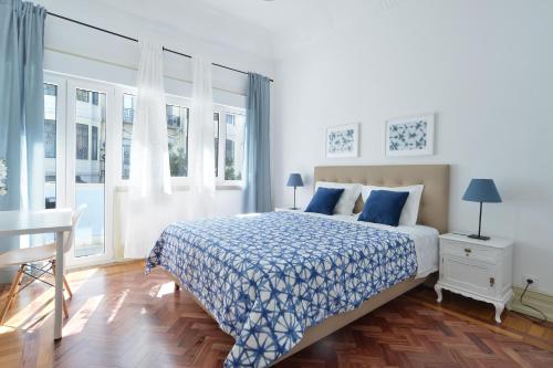 リスボンにあるQuartos do Marquêsのベッドルーム1室(ベッド1台、テーブル、窓付)