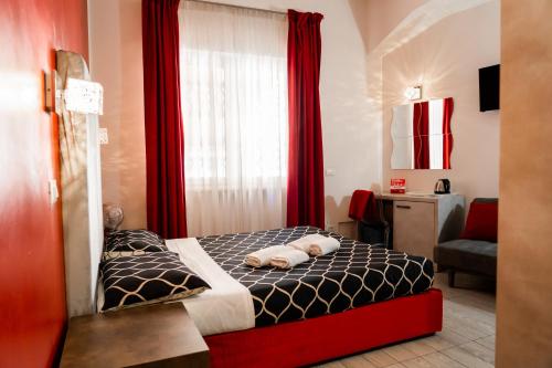 ローマにあるレ テラッツェ ディ サン ジョヴァンニのベッドルーム1室(ベッド1台付)、赤いカーテン付きの窓が備わります。