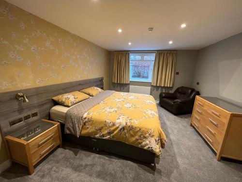 ein Schlafzimmer mit einem Bett und einem Stuhl in der Unterkunft Eden Vale Garden View Apartment with Patio in Morecambe
