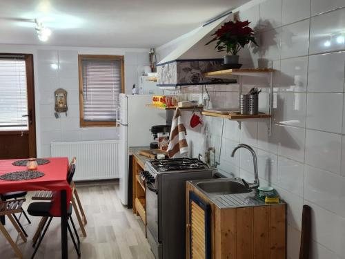 a small kitchen with a stove and a table at Tiny house Floare de colt in Moieciu de Sus