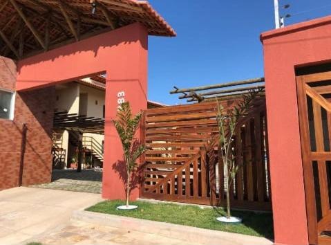 a red building with a wooden fence in front of it at Apartamento Sossego in Luis Correia