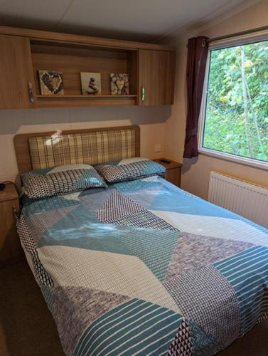 a bedroom with a large bed with a window at Caravan Littlesea Haven Weymouth Amazing Views in Weymouth