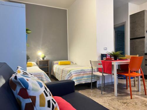 ein Zimmer mit zwei Betten und einem Tisch und Stühlen in der Unterkunft Bnbook Monolocale Beatrice Rho Fiera in Rho