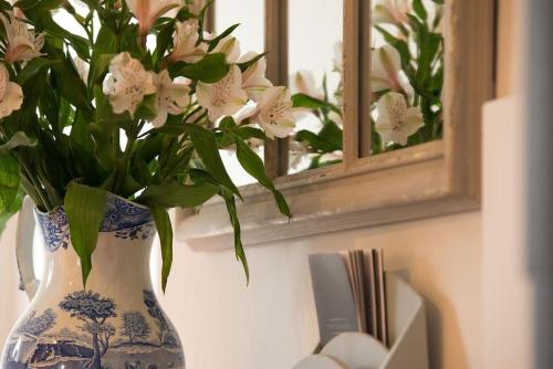 a blue and white vase with white flowers in it at The Stables, relax in 5 star style and comfort with lovely walks all around in Great Maplestead