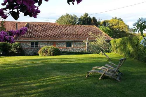 a bench sitting in the grass in front of a house at The Stables, relax in 5 star style and comfort with lovely walks all around in Great Maplestead