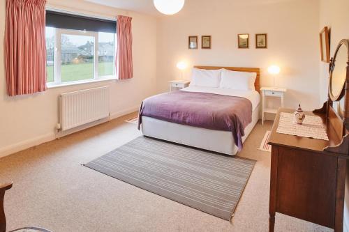 una camera d'albergo con letto e finestra di Host & Stay - Penrheol Farmhouse a Brecon
