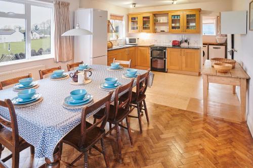 una cucina e una sala da pranzo con tavolo e sedie di Host & Stay - Penrheol Farmhouse a Brecon