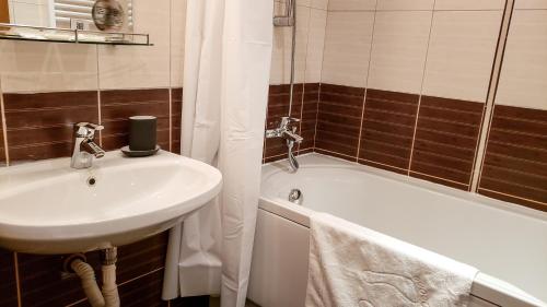 y baño con lavamanos, bañera y lavamanos. en Semiramida Gardens Apartments, en Borovets
