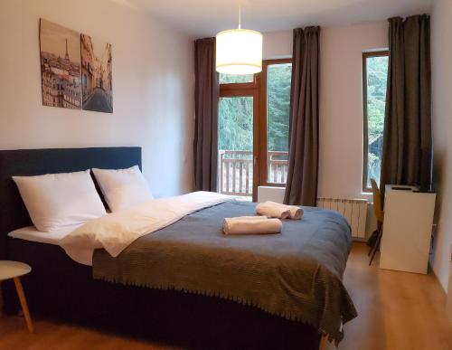 a bedroom with a bed with two towels on it at Semiramida Gardens Apartments in Borovets