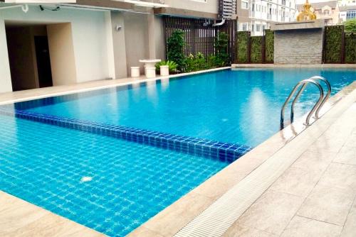 a large blue swimming pool in a building at Bitec Bts Bangna New Luxury room in Ban Khlong Samrong