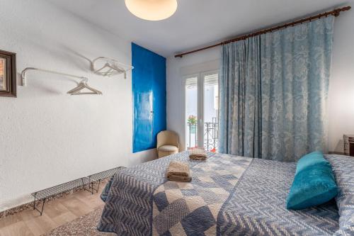 - une chambre avec des murs bleus, un lit et une fenêtre dans l'établissement Mijas Tropical, Casita típica, à Mijas