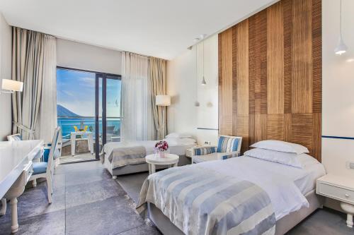 ブドヴァにあるHotel Braceraのベッド2台が備わる海の景色を望むホテルルームです。