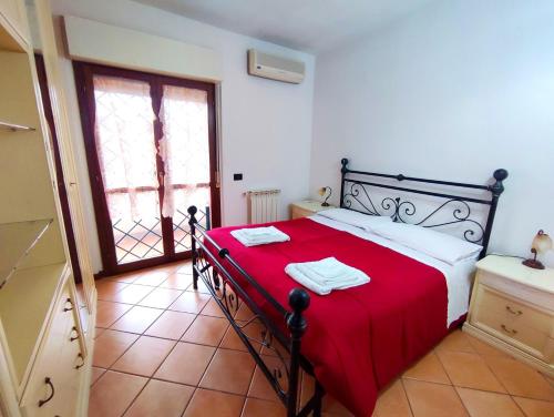 a bedroom with a bed with a red blanket at Villetta Acilia, 4 ospiti, giardino, parcheggio privato in Acilia