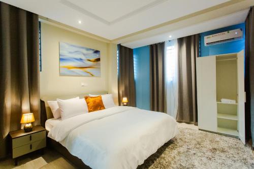 1 dormitorio con cama blanca y ventana grande en Accra Luxury Homes @ Achimota, en Chantan