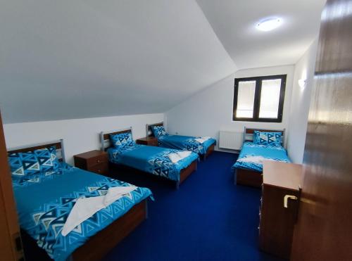 a room with three beds with blue sheets at Victorian Heights in Tetovo