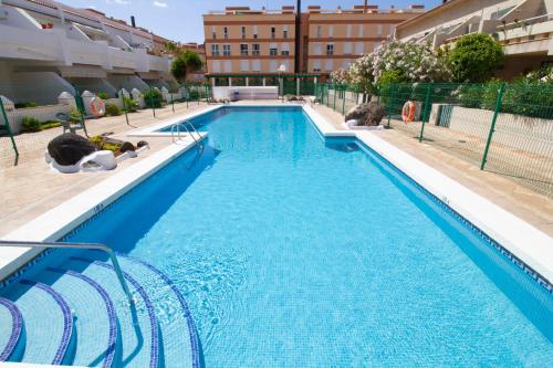 a large swimming pool with blue water at MEDANO4YOU The Bike Holiday Home in El Médano