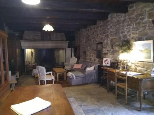un salon avec un canapé et une table dans l'établissement La longère d'Anaïde, à Saint Marcel Campes
