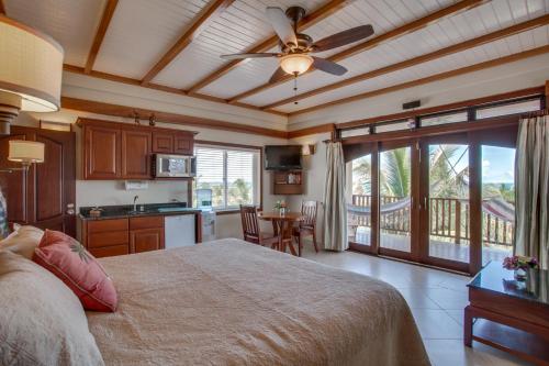 a bedroom with a bed and a kitchen with a balcony at Buttonwood Belize in Hopkins