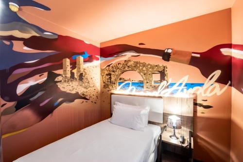 Habitación con cama y pintura en la pared en Muraless Art Hotel, en Castel d'Azzano