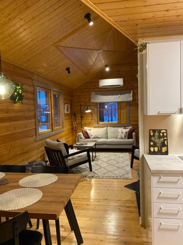 a living room with wooden walls and a wooden ceiling at Lomanaamanka Villa Kanerva in Syöte