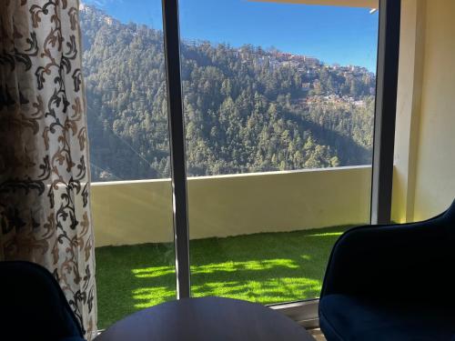 a large window with a view of a mountain at Calm Paradise in Shimla