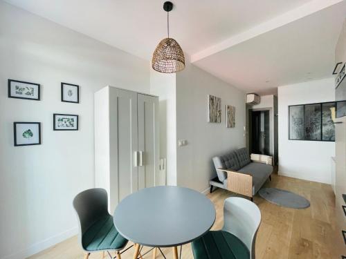 un salon avec une table, des chaises et un canapé dans l'établissement F1 neuf TURCKHEIM TUR102, à Cannes