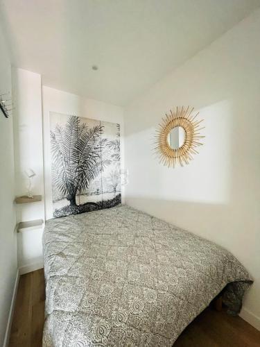 une chambre avec un lit et un miroir au mur dans l'établissement F1 neuf TURCKHEIM TUR102, à Cannes