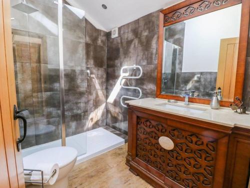 y baño con ducha, aseo y lavamanos. en Charming 2-Bed Cottage in Otley en Otley