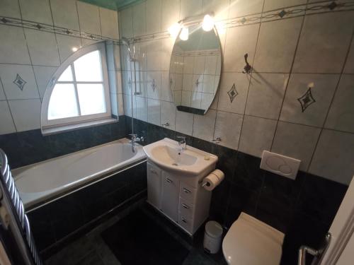 y baño con lavabo, bañera y aseo. en Vila Mirjam, en Radovljica