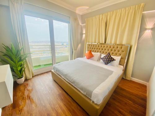 een slaapkamer met een bed en een groot raam bij Manchester Regency - 2BR Apartment in Dubai Marina in Dubai