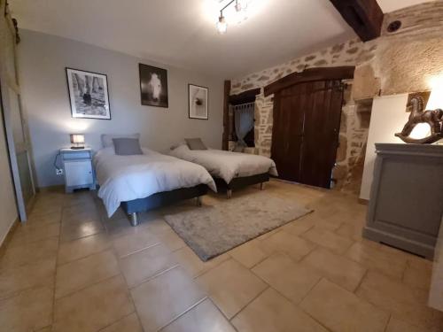 1 dormitorio con 2 camas y chimenea en Logement de charme en campagne girondine: le Domaine de Mongeret, en Pondaurat