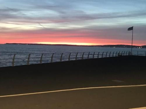 a view of the ocean from a pier at sunset at Beachfront pet friendly townhouse, Stunning views in Port Talbot