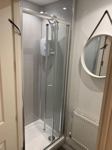 a glass shower in a bathroom with a mirror at Beachfront pet friendly townhouse, Stunning views in Port Talbot