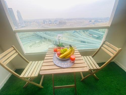 a table with a bowl of fruit on a balcony at Manchester Regency - 2BR Apartment in Dubai Marina in Dubai