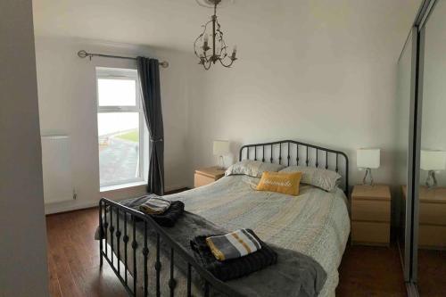a bedroom with a large bed and a window at Beachfront pet friendly townhouse, Stunning views in Port Talbot