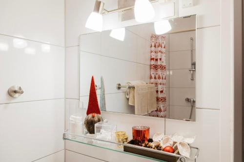 ein Badezimmer mit einem Spiegel und eine Katze auf einem Regal in der Unterkunft Knusperhäuschen in Sattendorf