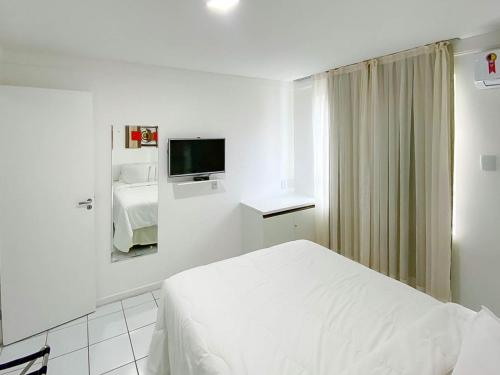 Habitación blanca con cama y TV en H Ponta Negra Beach - Luxo, en Natal