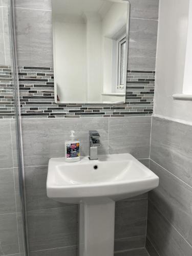 a bathroom with a white sink and a mirror at Tivoli Bungalow in Weston-super-Mare