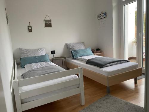 two beds sitting next to each other in a room at Schöne&zentrale Ferienwohnung in Schwelm in der Nähe von Wuppertal,Düsseldorf, Köln,Ruhrgebiet in Schwelm