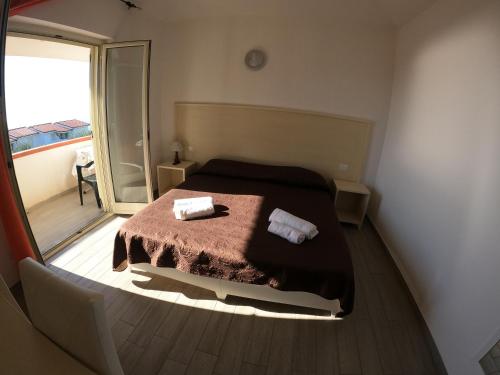 een slaapkamer met een bed met twee handdoeken erop bij Agriturismo Seaview in Capo Vaticano