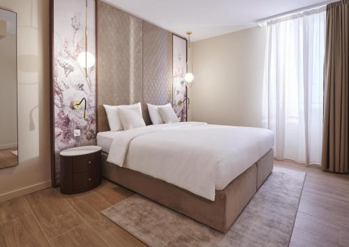 - une chambre avec un grand lit et une grande fenêtre dans l'établissement Vista Lakefront Boutique Hotel, à Ascona