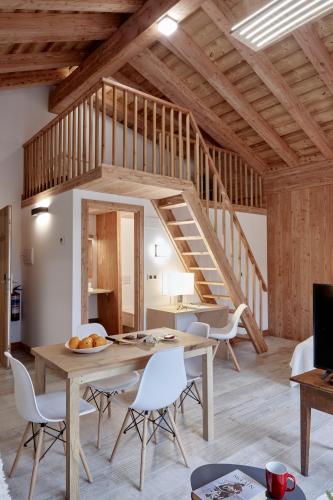 a living room with a table and chairs and a staircase at Apartamentos Ea Astei in Ea