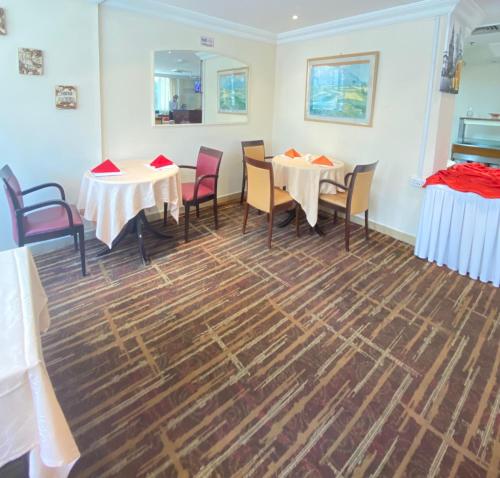 a dining room with two tables and chairs at Al Diar Mina Hotel in Abu Dhabi