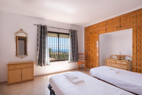 1 dormitorio con 2 camas y ventana en Villa Andres - PlusHolidays, en Calpe