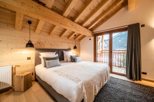 a bedroom with a large bed and a large window at Chalet Arande Saint Gervais - by EMERALD STAY in Saint-Gervais-les-Bains